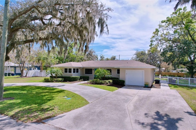 ranch-style house with a garage, concrete driveway, fence, a front lawn, and stucco siding