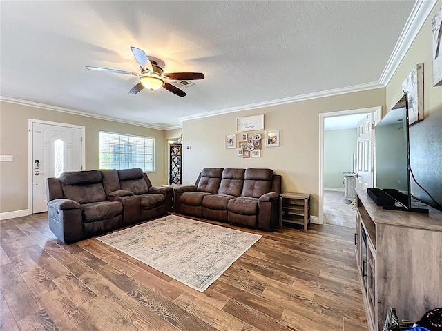 living room featuring crown molding, a ceiling fan, a textured ceiling, wood finished floors, and baseboards