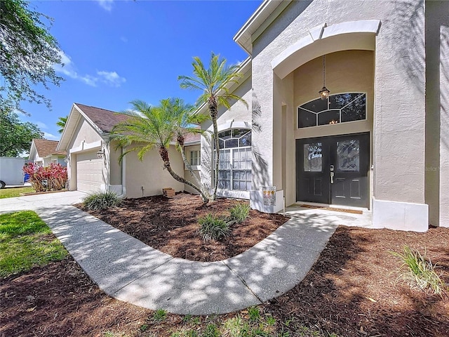 property entrance featuring a garage and stucco siding