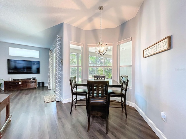 dining space with dark wood-type flooring, a notable chandelier, and baseboards