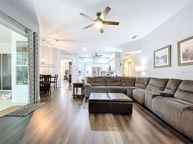 living area with dark wood-type flooring, visible vents, and a ceiling fan