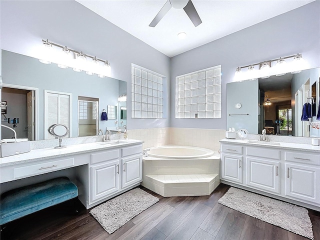 full bathroom featuring a sink, ceiling fan, and a garden tub