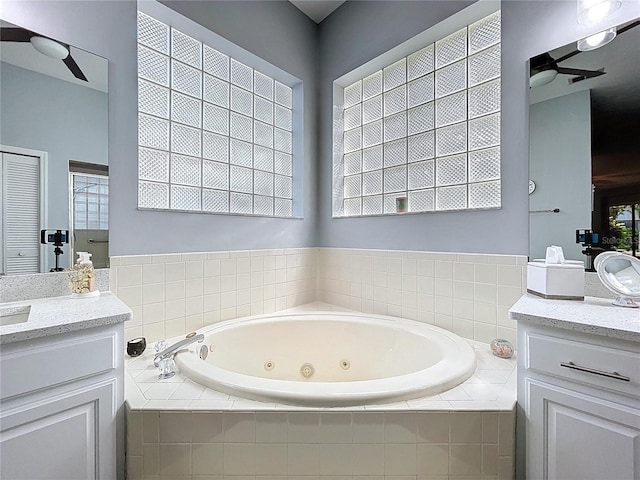 full bathroom featuring vanity, ceiling fan, and a tub with jets