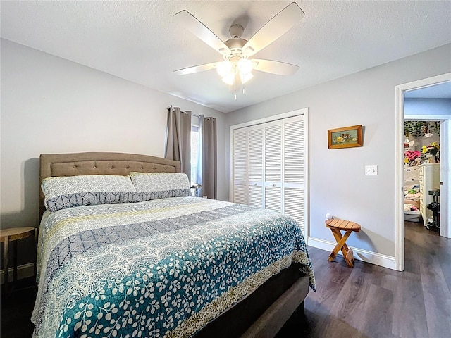 bedroom featuring a closet, baseboards, a textured ceiling, and dark wood finished floors