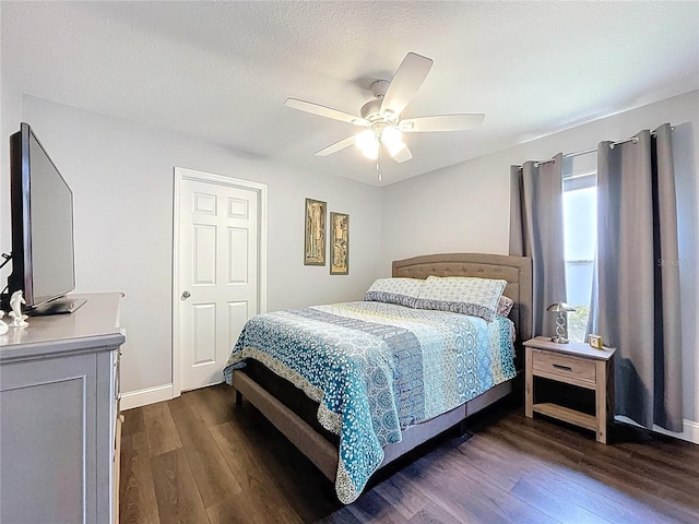 bedroom featuring a ceiling fan, a textured ceiling, baseboards, and dark wood-style floors