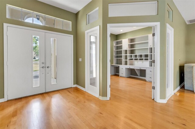 6928 Hayter Ln, Lakeland, FL 33813 - foyer entrance featuring wood finished floors, a high ceiling, baseboards, and french doors