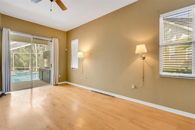 6928 Hayter Ln, Lakeland, FL 33813 - unfurnished room with wood finished floors, a healthy amount of sunlight, baseboards, and ceiling fan