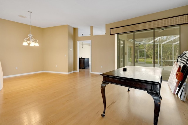 6928 Hayter Ln, Lakeland, FL 33813 - living room with baseboards, a notable chandelier, and light wood-style floors