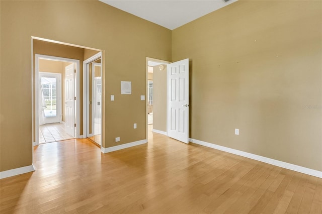 6928 Hayter Ln, Lakeland, FL 33813 - spare room featuring light wood-type flooring, a towering ceiling, and baseboards