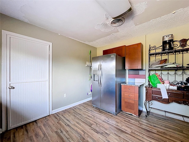 105 Old Connersville Rd, Bartow, FL 33830 - kitchen featuring stainless steel fridge, light wood-style floors, baseboards, brown cabinetry, and light stone counters