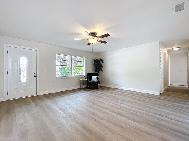 foyer featuring a ceiling fan, light wood-style flooring, and baseboards