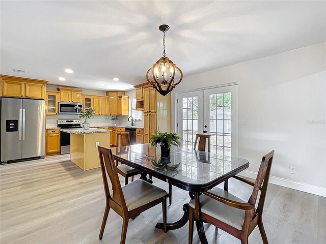 dining area featuring a chandelier, light wood-type flooring, baseboards, french doors, and recessed lighting