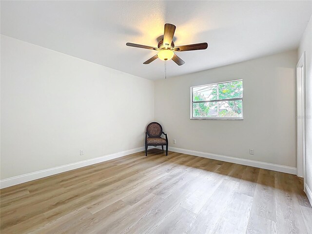 empty room featuring a ceiling fan, light wood-style floors, and baseboards