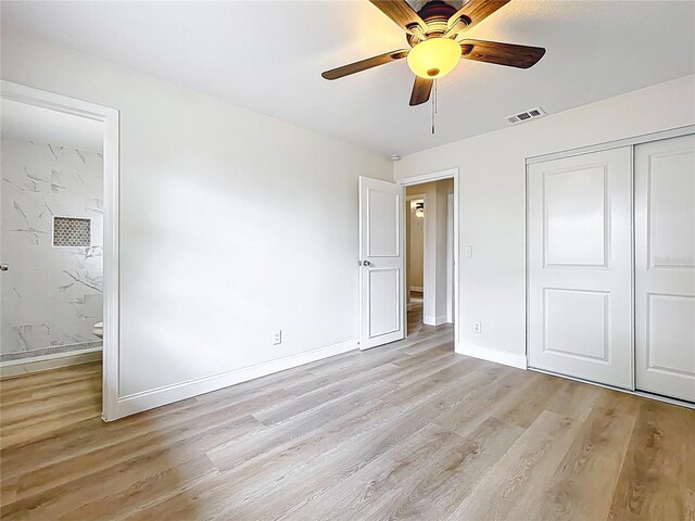 unfurnished bedroom featuring light wood-style floors, baseboards, a closet, and ensuite bath