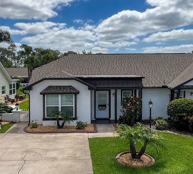 3804 Perugia Ave, Sebring, FL 33872 - view of front of property with stucco siding, a front yard, and a shingled roof
