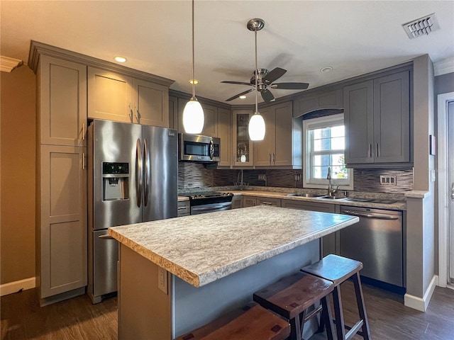3804 Perugia Ave, Sebring, FL 33872 - kitchen with stainless steel appliances, a sink, ceiling fan, decorative backsplash, and a kitchen bar