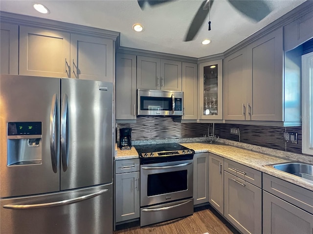 3804 Perugia Ave, Sebring, FL 33872 - kitchen with stainless steel appliances, gray cabinetry, dark wood-type flooring, glass insert cabinets, and decorative backsplash
