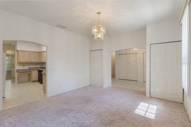 1131 Country Oaks Blvd, Lake Wales, FL 33898 - unfurnished living room featuring arched walkways, a chandelier, and light colored carpet