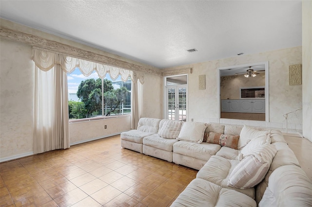 900 Howard Ter NW, Winter Haven, FL 33881 - living room featuring a textured ceiling, baseboards, and ceiling fan
