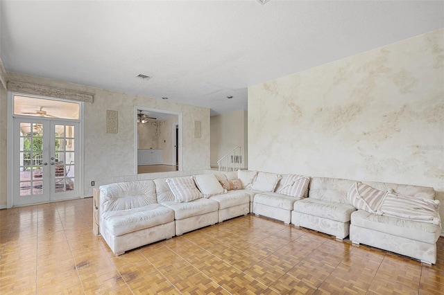 900 Howard Ter NW, Winter Haven, FL 33881 - living area featuring french doors, wallpapered walls, stairway, and ceiling fan