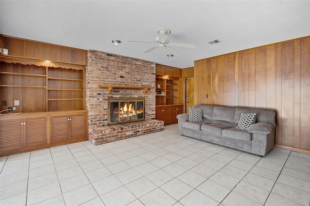 900 Howard Ter NW, Winter Haven, FL 33881 - living area featuring wood walls, a ceiling fan, built in features, tile patterned flooring, and a brick fireplace