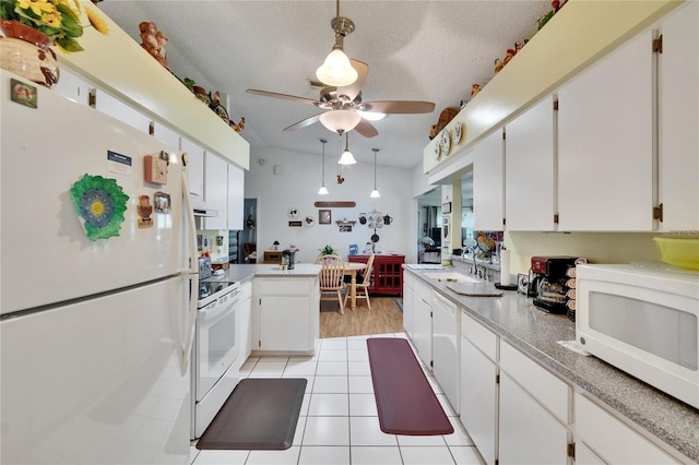 3154 Prairie Dunes Cir W, Lakeland, FL 33810 - kitchen with white appliances, ceiling fan, light countertops, white cabinetry, and a peninsula