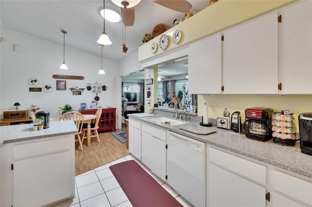 3154 Prairie Dunes Cir W, Lakeland, FL 33810 - kitchen with dishwasher, white cabinets, lofted ceiling, hanging light fixtures, and light tile patterned flooring