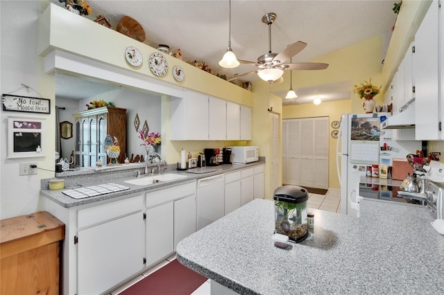 3154 Prairie Dunes Cir W, Lakeland, FL 33810 - kitchen with white appliances, under cabinet range hood, a ceiling fan, white cabinets, and a peninsula
