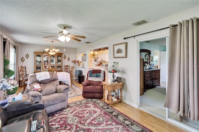 3154 Prairie Dunes Cir W, Lakeland, FL 33810 - living area with wood finished floors, a textured ceiling, ceiling fan, and a chandelier
