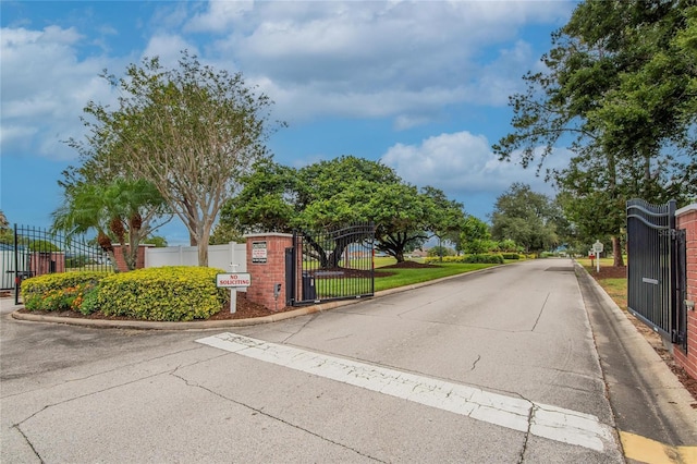 3154 Prairie Dunes Cir W, Lakeland, FL 33810 - view of asphalt road with curbs, a gate, a gated entry, and traffic signs
