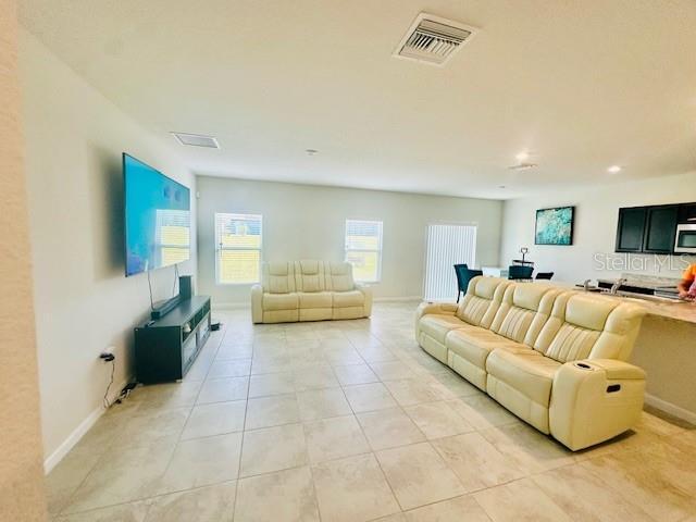 264 Fiddlewood Ct, Davenport, FL 33837 - living area featuring light tile patterned floors and baseboards