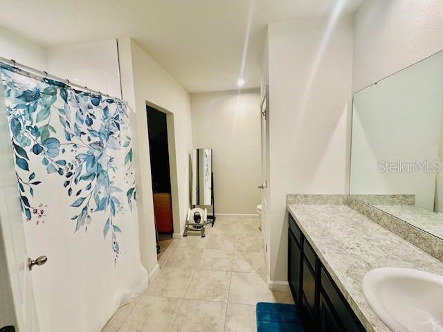 264 Fiddlewood Ct, Davenport, FL 33837 - bathroom featuring vanity, tile patterned flooring, and curtained shower