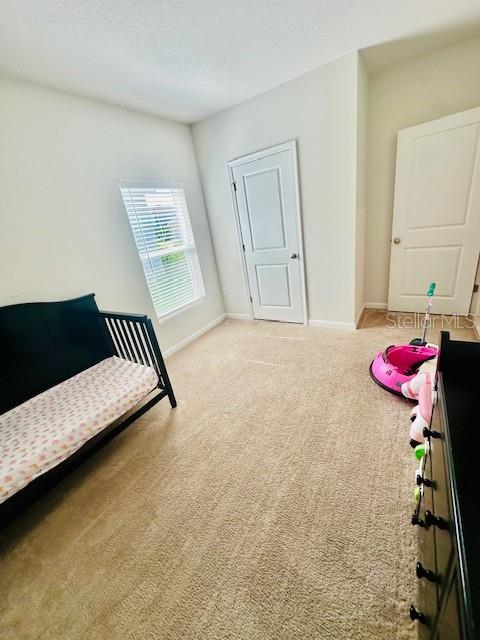 264 Fiddlewood Ct, Davenport, FL 33837 - bedroom with carpet flooring and a textured ceiling