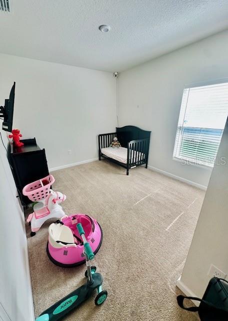 264 Fiddlewood Ct, Davenport, FL 33837 - unfurnished bedroom with carpet flooring and a textured ceiling