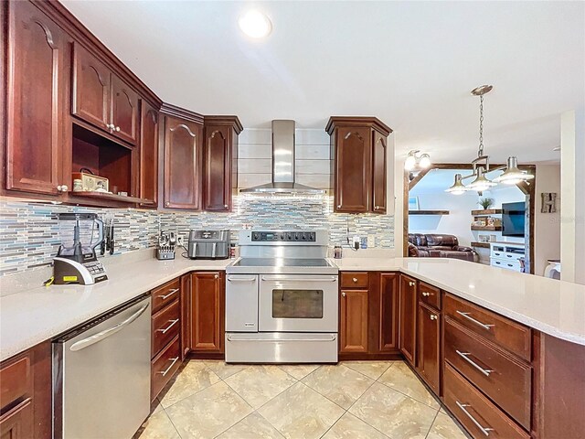 4966 Foxrun Ln, Lakeland, FL 33813 - kitchen with appliances with stainless steel finishes, wall chimney range hood, light countertops, a peninsula, and tasteful backsplash