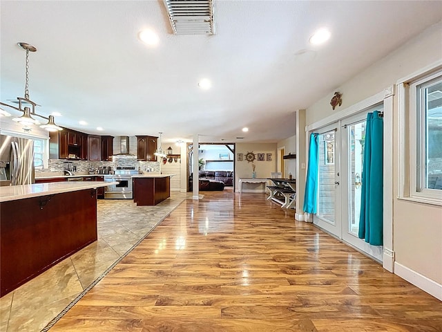 4966 Foxrun Ln, Lakeland, FL 33813 - kitchen with appliances with stainless steel finishes, wall chimney range hood, dark brown cabinets, light countertops, and recessed lighting