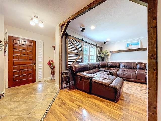 4966 Foxrun Ln, Lakeland, FL 33813 - living room with ornamental molding, a barn door, a textured ceiling, and light wood-type flooring