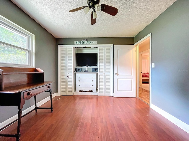 4966 Foxrun Ln, Lakeland, FL 33813 - bedroom with wood finished floors, a textured ceiling, a closet, and ceiling fan