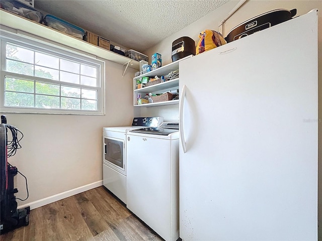 4966 Foxrun Ln, Lakeland, FL 33813 - washroom featuring independent washer and dryer, a textured ceiling, and wood finished floors