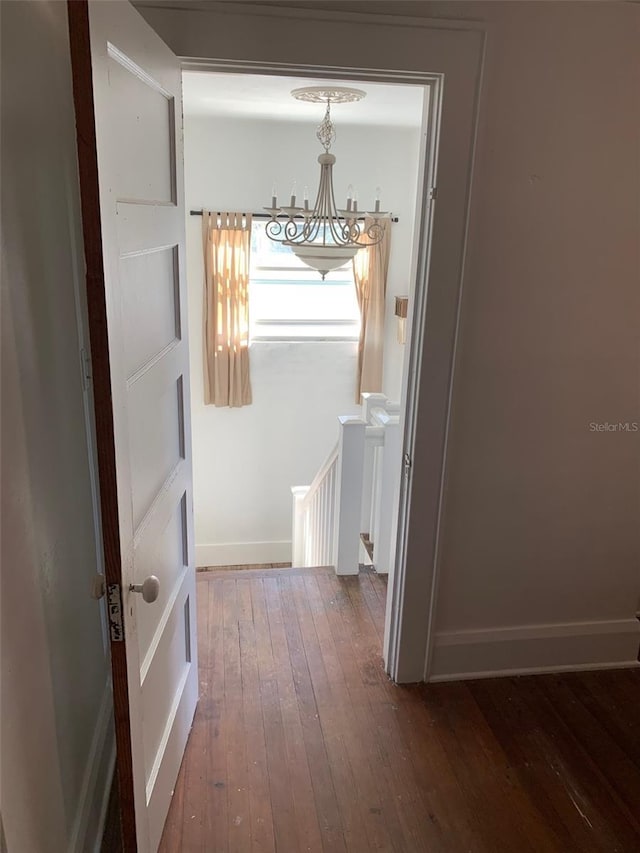 402 S Franklin St, Sebring, FL 33870 - corridor featuring a chandelier, dark wood-style flooring, and an upstairs landing