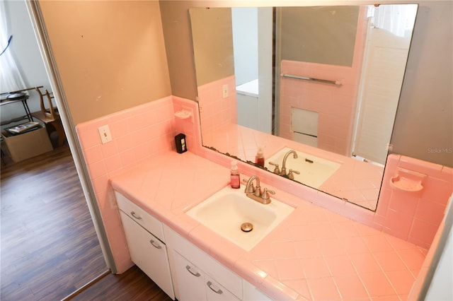 733 Oleander Dr SE, Winter Haven, FL 33880 - bathroom with wood finished floors, tile walls, vanity, and wainscoting