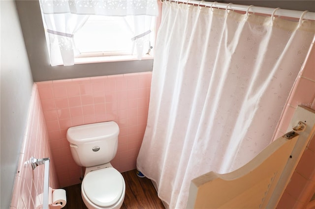 733 Oleander Dr SE, Winter Haven, FL 33880 - bathroom featuring tile walls, wood finished floors, a shower with curtain, a bath, and a wainscoted wall