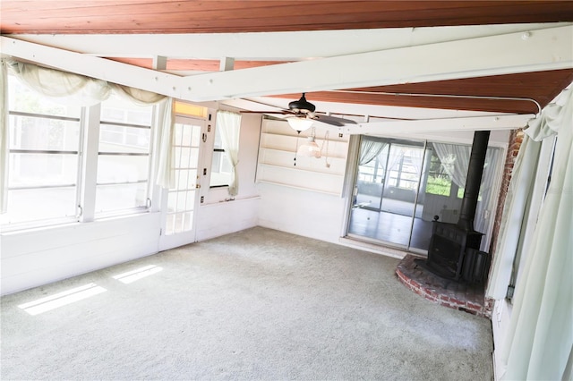 733 Oleander Dr SE, Winter Haven, FL 33880 - unfurnished living room with carpet floors, a wood stove, and a ceiling fan