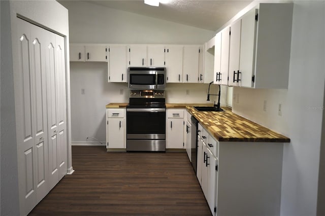 1922 N Torrington Rd N, Avon Park, FL 33825 - kitchen with appliances with stainless steel finishes, dark wood-style flooring, lofted ceiling, white cabinetry, and wood counters
