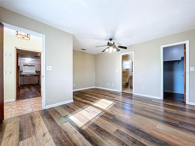 1711 Estes Rd, Bartow, FL 33830 - unfurnished bedroom with wood finished floors, a spacious closet, connected bathroom, and a ceiling fan