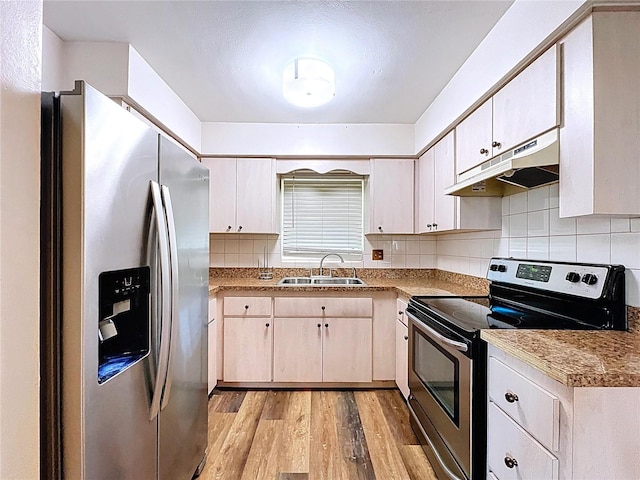 1711 Estes Rd, Bartow, FL 33830 - kitchen featuring appliances with stainless steel finishes, under cabinet range hood, light wood-type flooring, backsplash, and light countertops