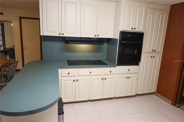 111 Deen Blvd, Auburndale, FL 33823 - kitchen with black appliances, white cabinets, light tile patterned floors, under cabinet range hood, and dark countertops