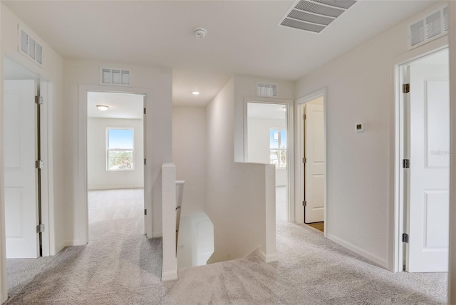 hallway with light colored carpet