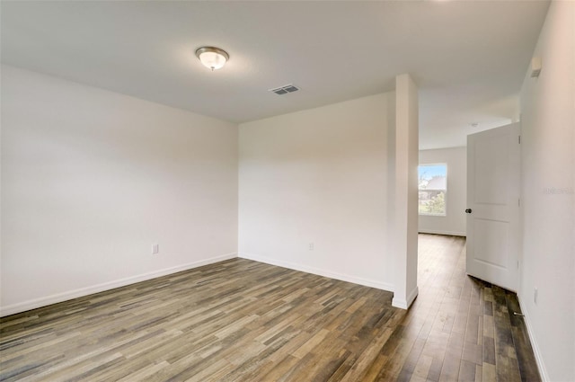 unfurnished room with dark hardwood / wood-style flooring