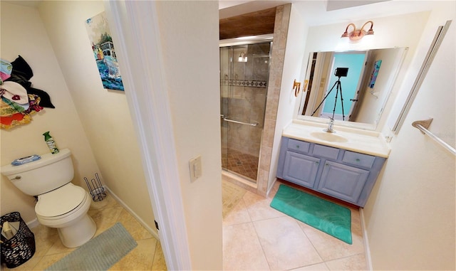 bathroom featuring tile patterned flooring, vanity, a shower with door, and toilet